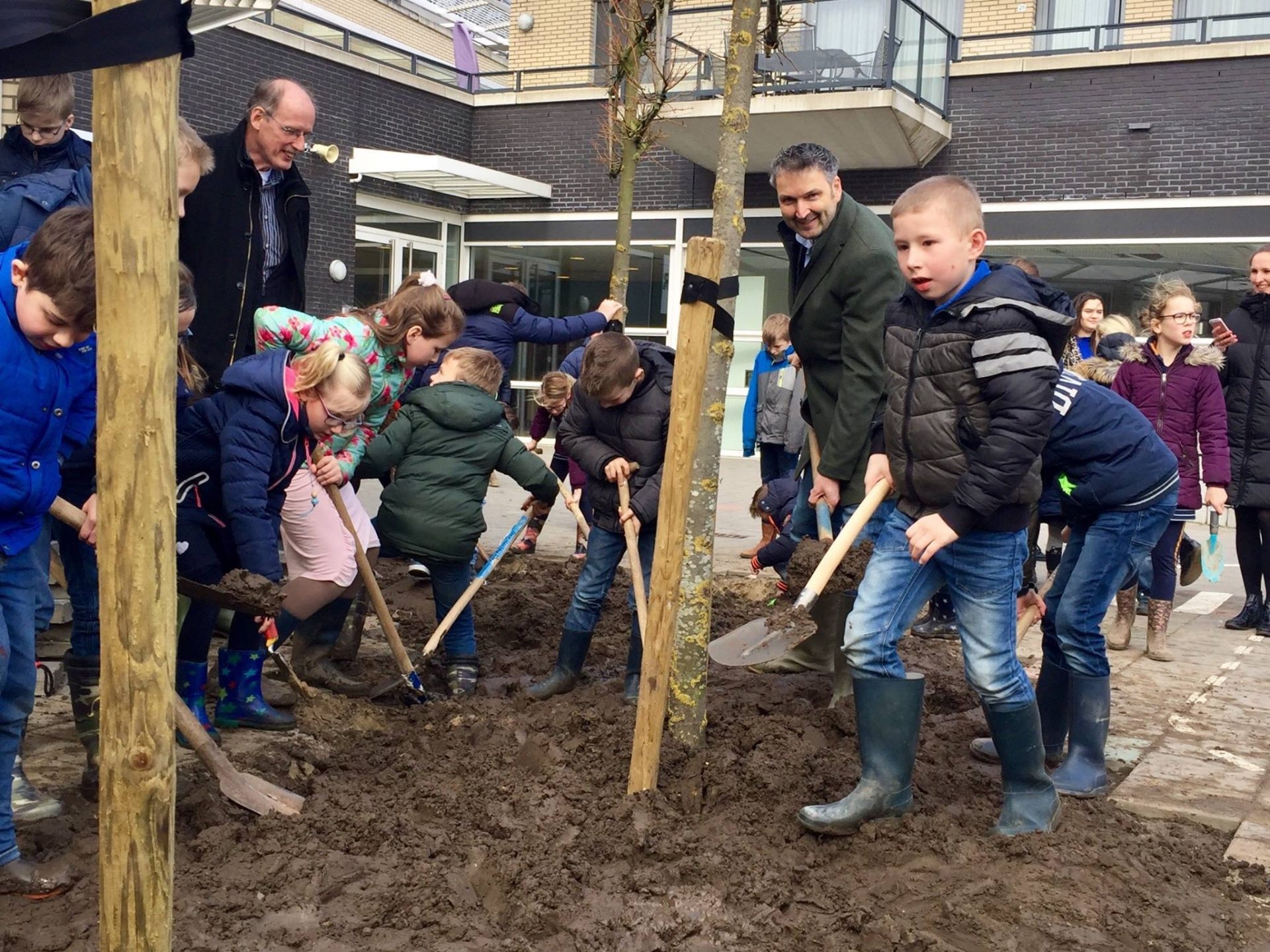 Wethouder plant de eerste bomen samen met leerlingen van De Akker